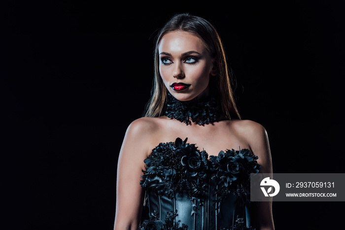 scary vampire girl in black gothic dress looking away isolated on black