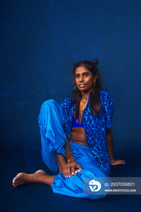 portrait of dark skinned Indian woman from Malaysia against dark blue background