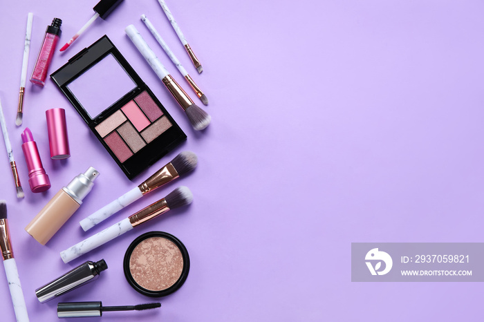 Different makeup products on purple background