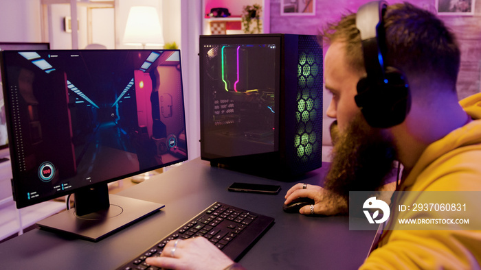 Young man wearing headphones while playing online video games