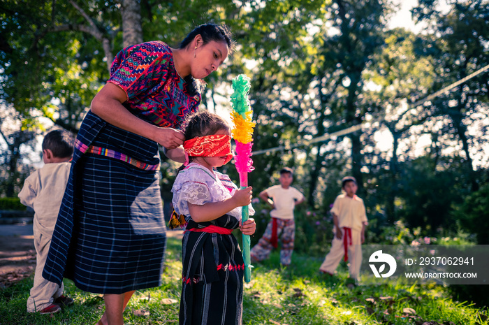 Madre y su pequeña hija en la fiesta de cumpleaños de piñata.