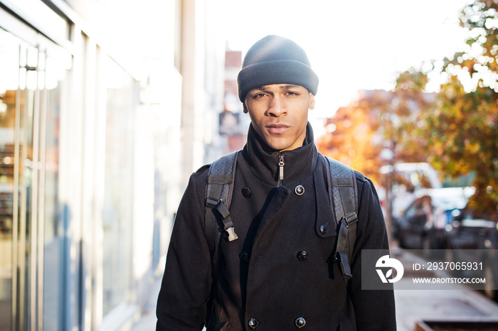 Portrait of young man standing on sidewalk