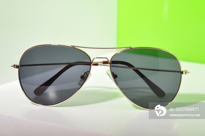 Sunglasses on white and green background