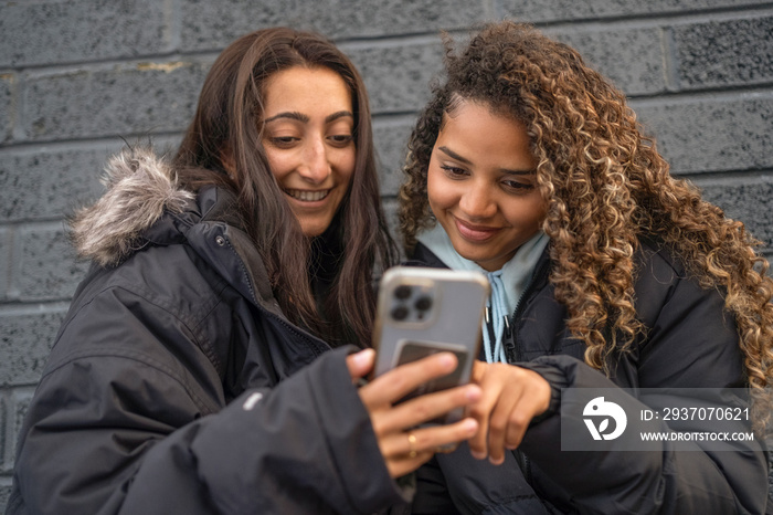 Two young women looking at smartphone