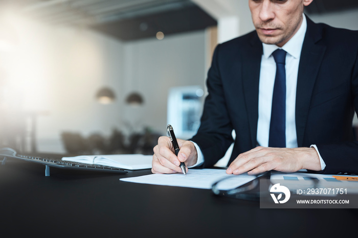 Businessman sitting at his office desk going over paperwork