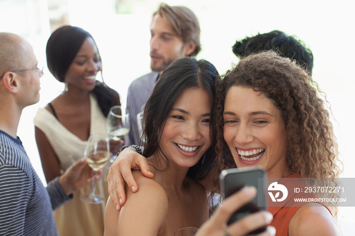 Happy young women friends taking selfie at party