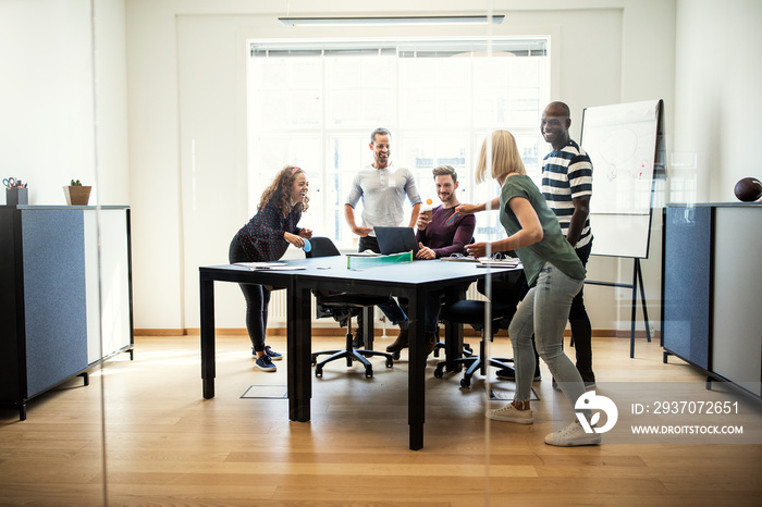 Young designers laughing and playing table tennis during their b