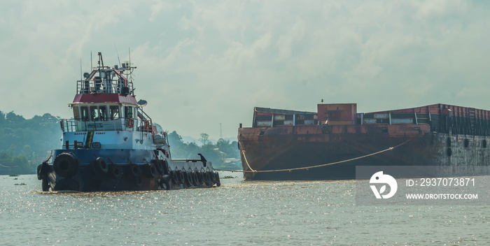 Tugboat pulling heavy loaded barge of black coal in the Mahakam river, Indonesia