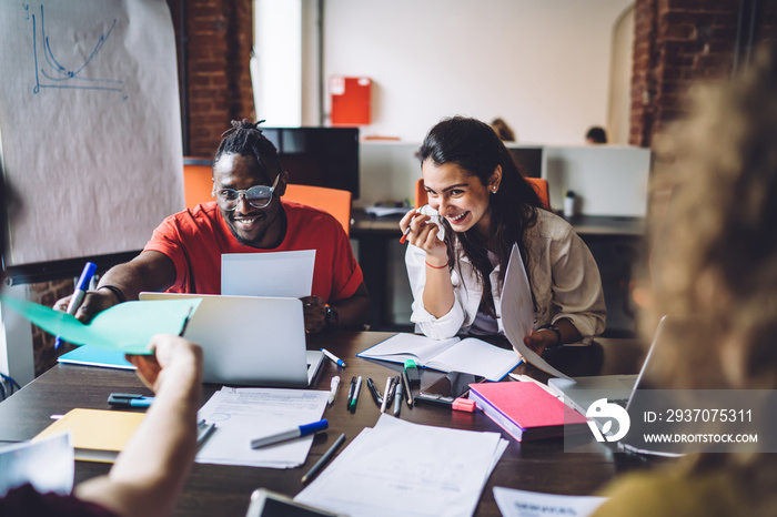 Laughing diverse students working in team