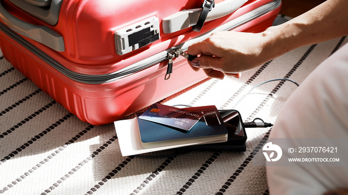 Close up of woman hand holding zips close the baggage suitcase.