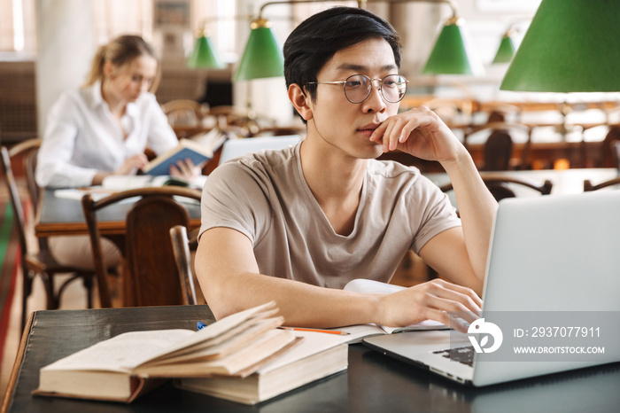 Smart cheerful teenagers studying at the library together