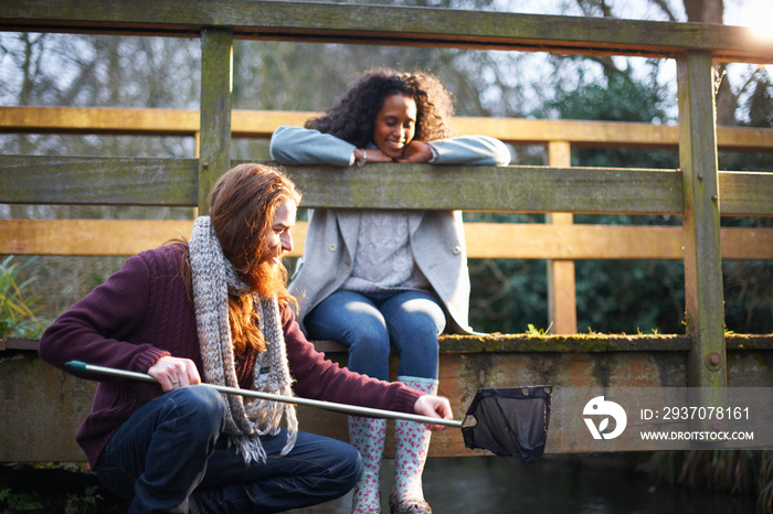 Couple fishing on bridge in countryside