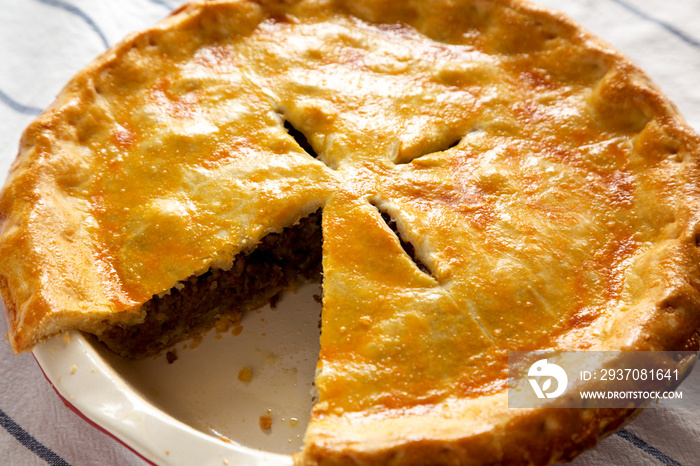 Tasty Homemade Canadian Tourtiere Meat Pie on a white plate , low angle view. Close-up.