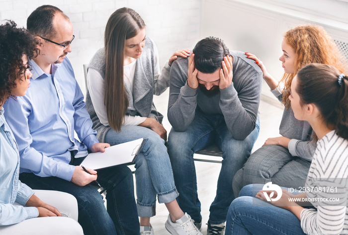 Depressed man with alcoholism problem sitting in rehab center