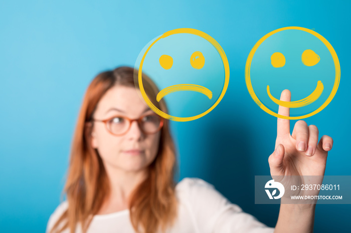 Hand is selecting a happy mood smiley. In front of an empty room.