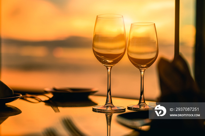 Romantic luxury dinner.Empty glasses and tropical sunset with sea background.Romantic evening with s