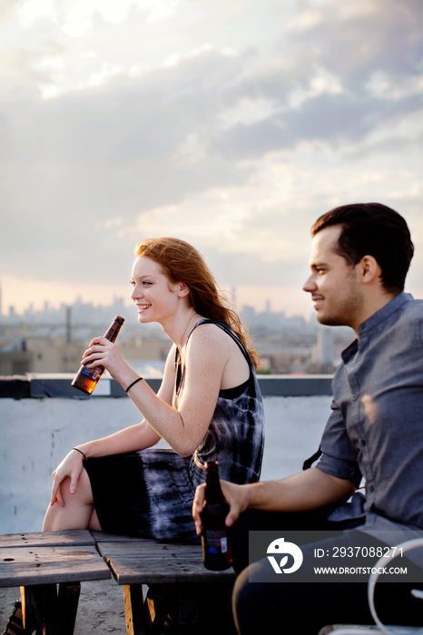 Friends having beer on roof of building