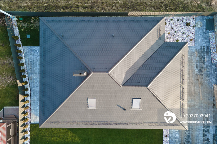 Aerial view of house roof top covered with ceramic shingles. Tiled covering of building under constr