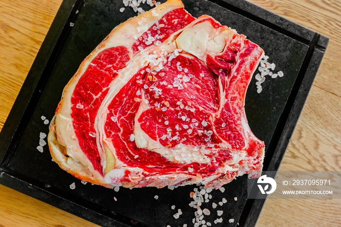 Pezzo di carne cruda fotografato dallalto con sale grosso in un piatto nero