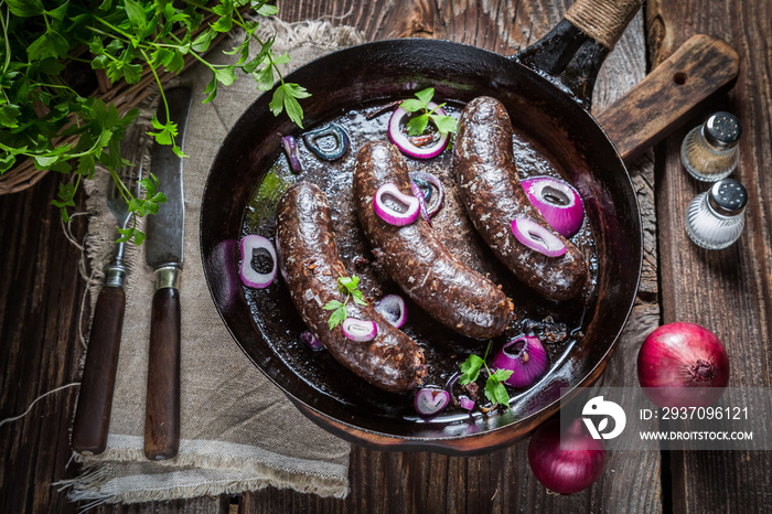 Hot black pudding with parsley and onion on pan