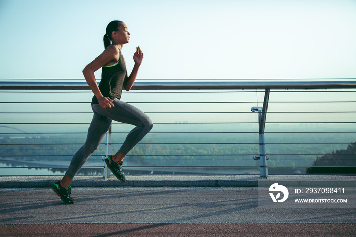 Slim determined sportswoman running outside stock photo