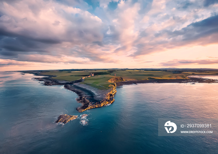 View from the air to  the Embleton sea shore, North sea, the cliff with seagulls, ruins and green fi