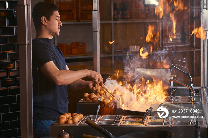 亚洲餐厅的烹饪过程。烹饪是在炒锅里用香料和酱汁炒蔬菜。