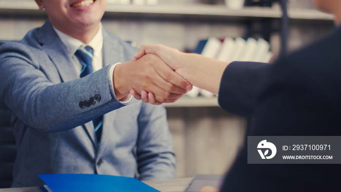 Asian businessman shaking hands partnership deal business while standing indoors in the office, Happ