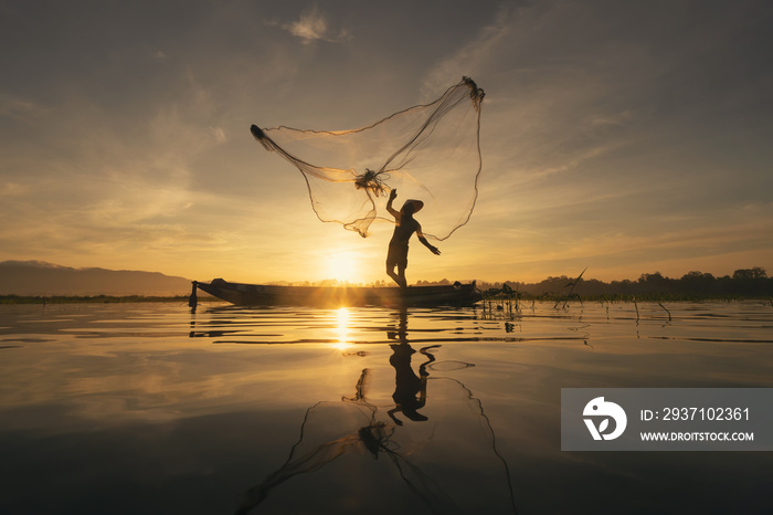 Silhouette Fisherman casting or throwing a net for catching freshwater fish in nature lake or river 