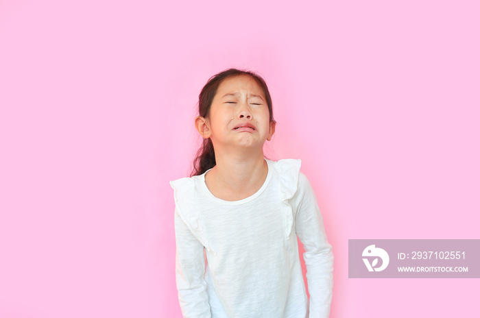 Portrait asian little girl crying isolated on pink background. Angry kid with sad expressions and sc