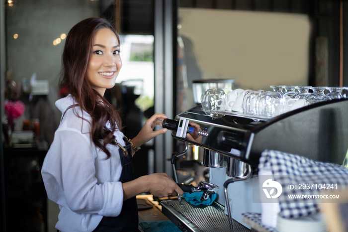 Asian women Barista smiling and using coffee machine in coffee shop counter - Working woman small bu