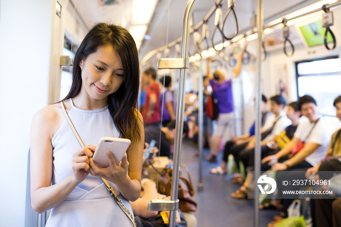 Woman using cellphone inside train compartment