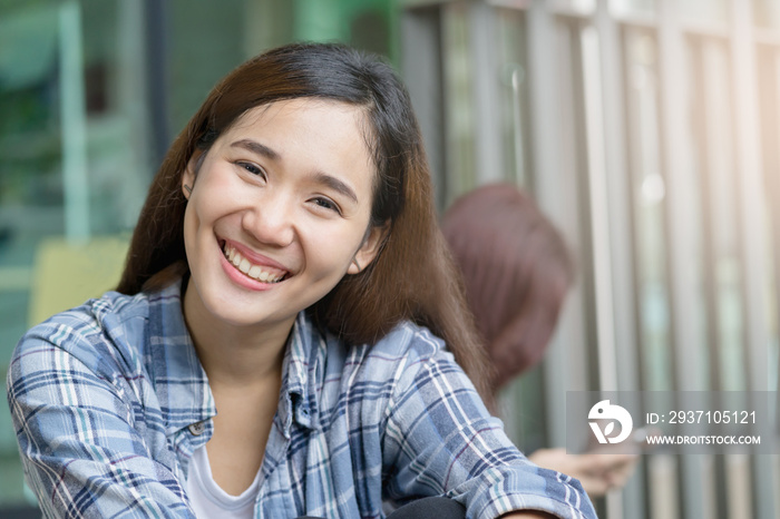 A portrait of a beautiful asian woman smiling brightly at the camera.