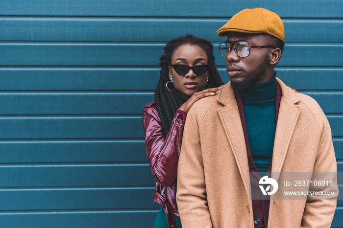 美丽时尚的年轻非裔美国夫妇穿着夹克和大衣在外面合影