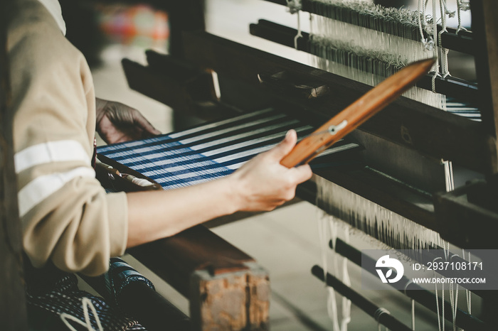 Woman hand weaving to make cloth fabric