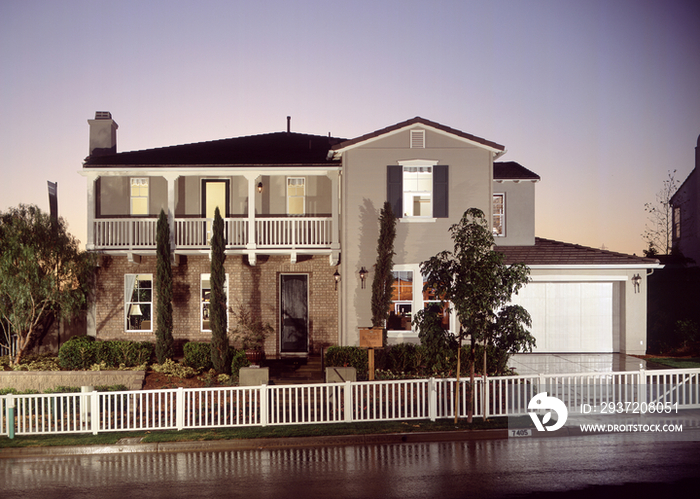 Two story house with garage at dusk