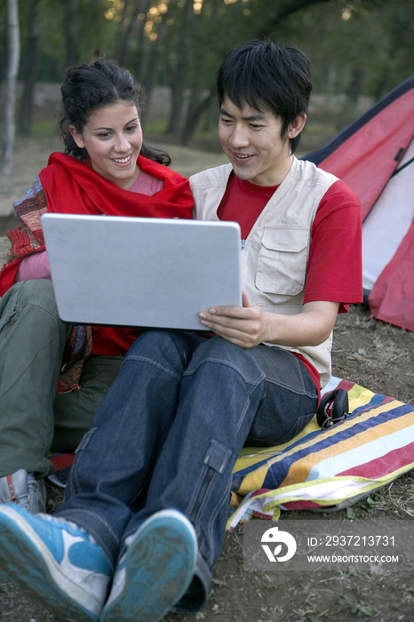 年轻情侣在户外使用笔记本电脑