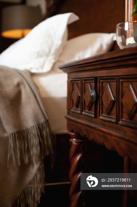 Close-up of wooden bedside table by blurred bed at home; Scottsdale; USA