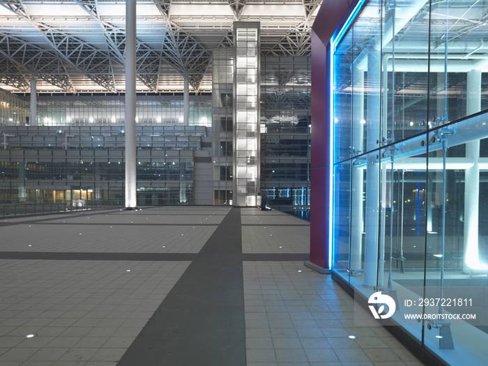 Red framed glass structure and walkway with columned ceiling in modern office building