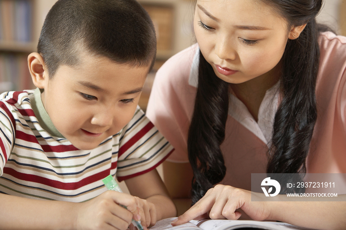 老师教导小男孩学习