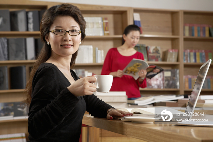 商务女性在公司看书喝咖啡
