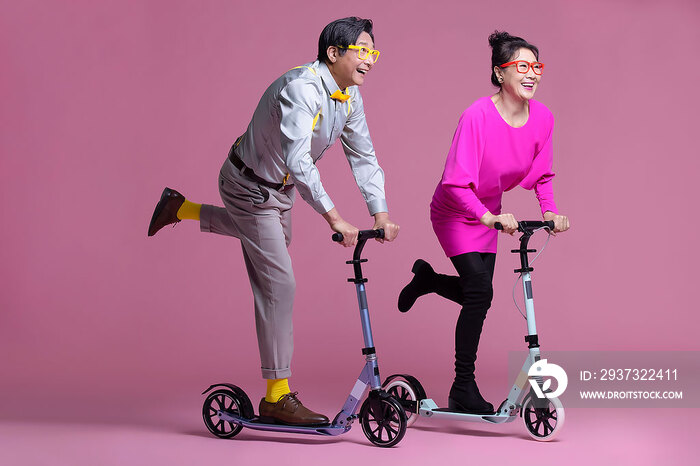 幽默时尚的老年夫妇骑滑板车