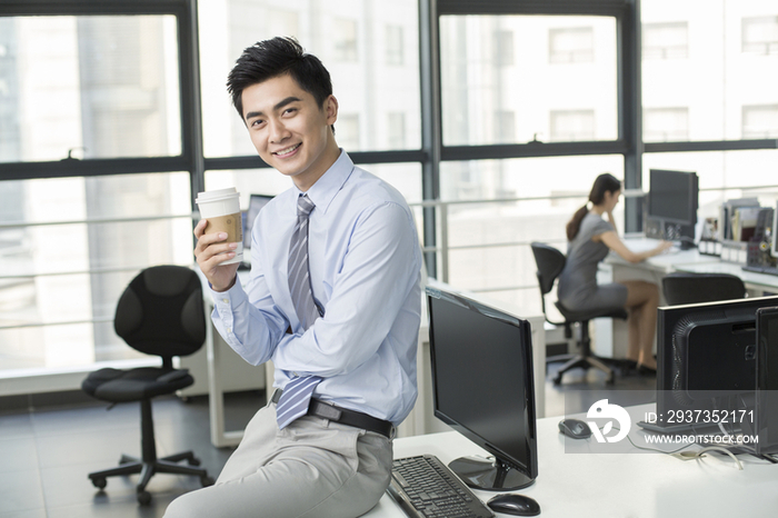 年轻商务男士在办公室喝咖啡