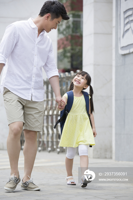 父亲接女儿放学回家