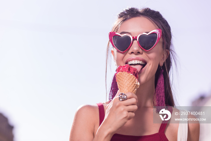 甜冰淇淋。快乐乐观的女人戴着墨镜享受冰淇淋