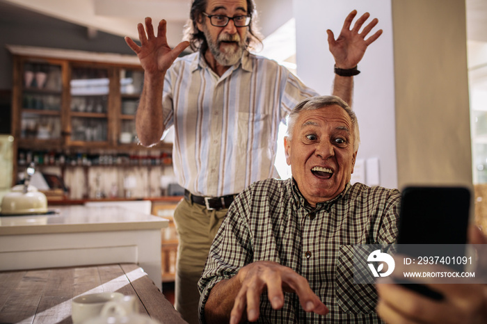 Retired men making funny faces while taking selfie