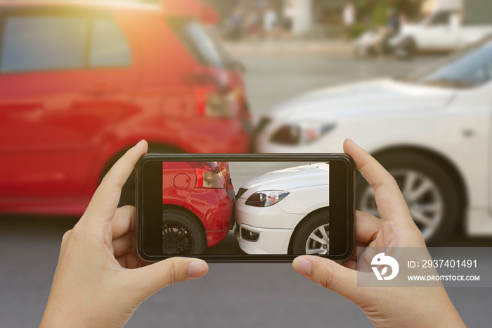 Close up hand holding smartphone and take photo at The scene of a car crash and accident, car accide