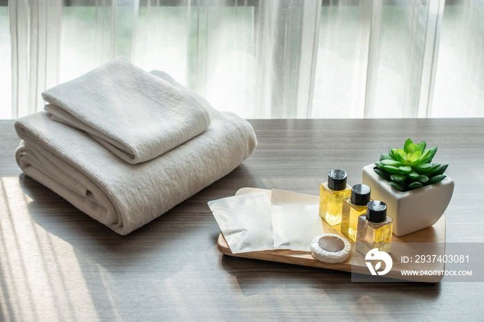 Set of hotel amenities (such as towels, shampoo, soap etc) on the bed. Hotel amenities is something 