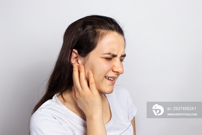 The woman has a sore ear - infection, inflammation from infection and otitis. Perforation ruptured t