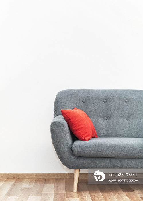 现代灰色沙发，木质瓷砖地板上有红色枕头——办公家具，白墙——空间